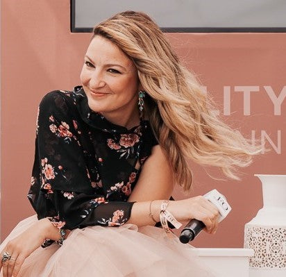 A photo of Ioana smiling against a colorful background