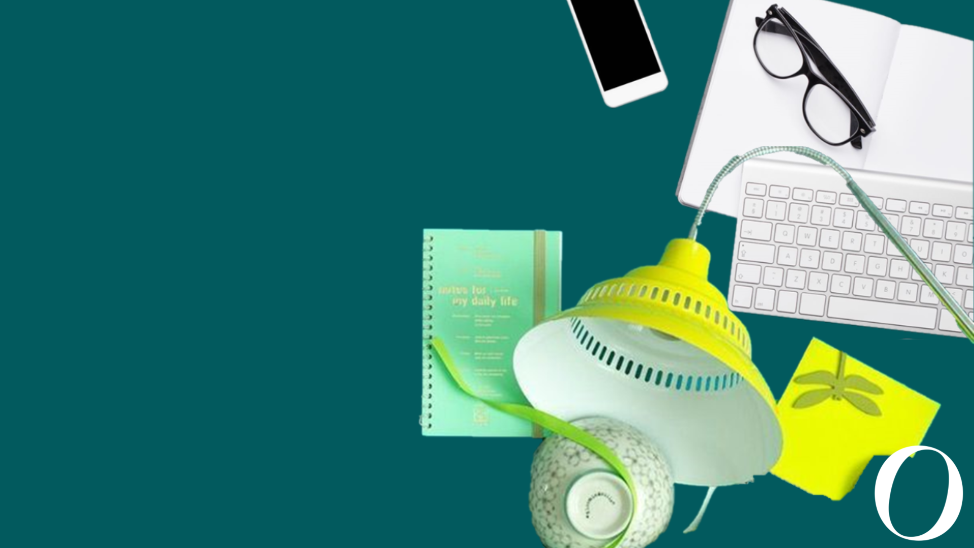 A variety of typical items you find on a desk - a lamp, post its, keyboard, phone, glasses and a teacup 
