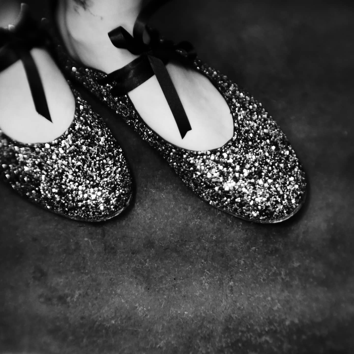 Myself wearing the ballerina flats showcasing the contrast of the black satin laces and the sparkle of the shoes