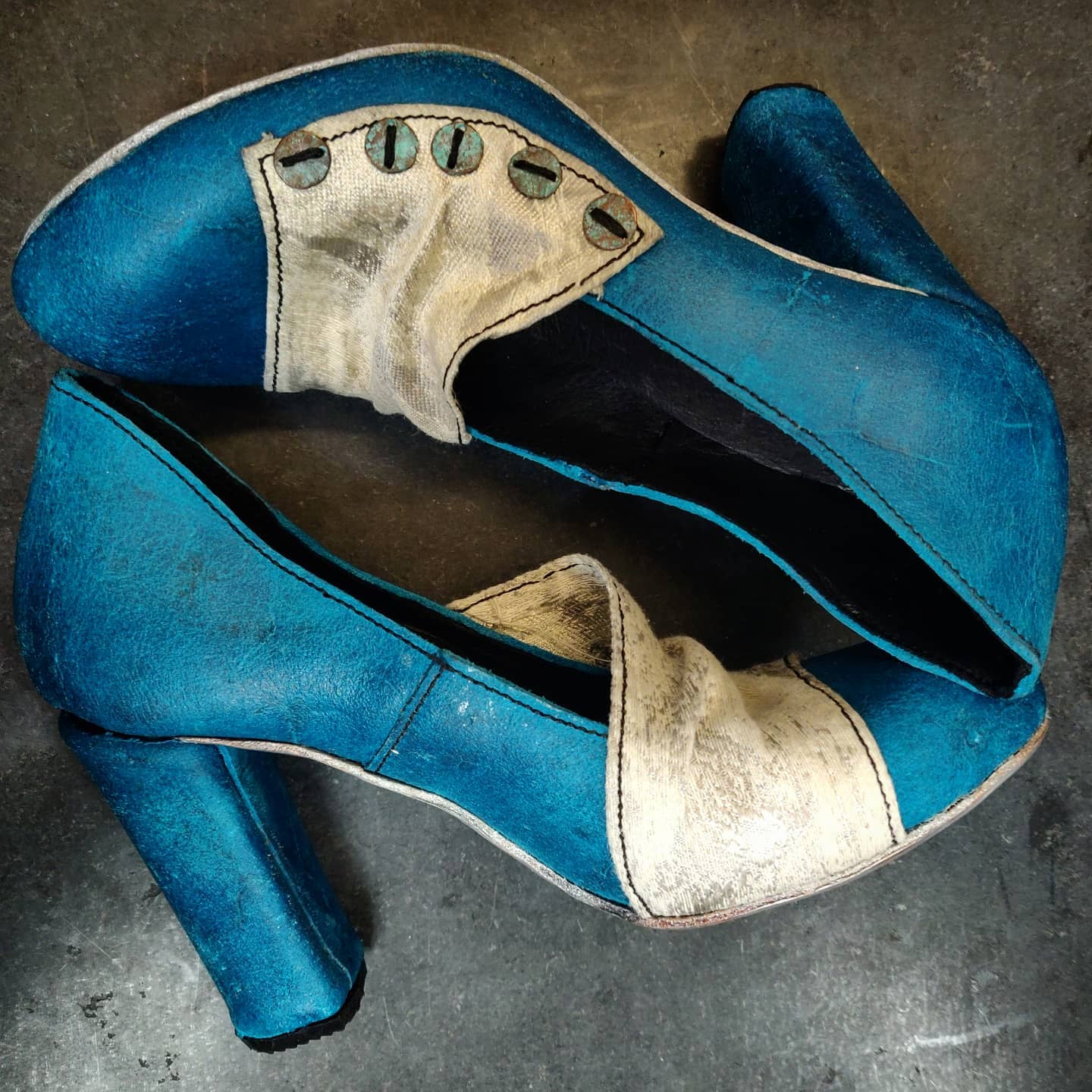 Focus on the lateral side of the shoes and the play of contrasts between the blue leather and the grey fabric and the silver soles