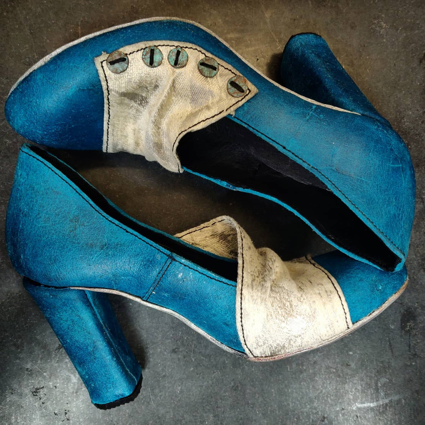 Focus on the lateral side of the shoes and the play of contrasts between the blue leather and the grey fabric and the silver soles