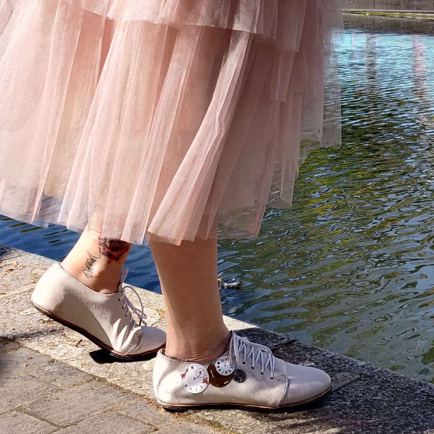 Myself modelling the shoes with a pink tule skirt with a waterway background