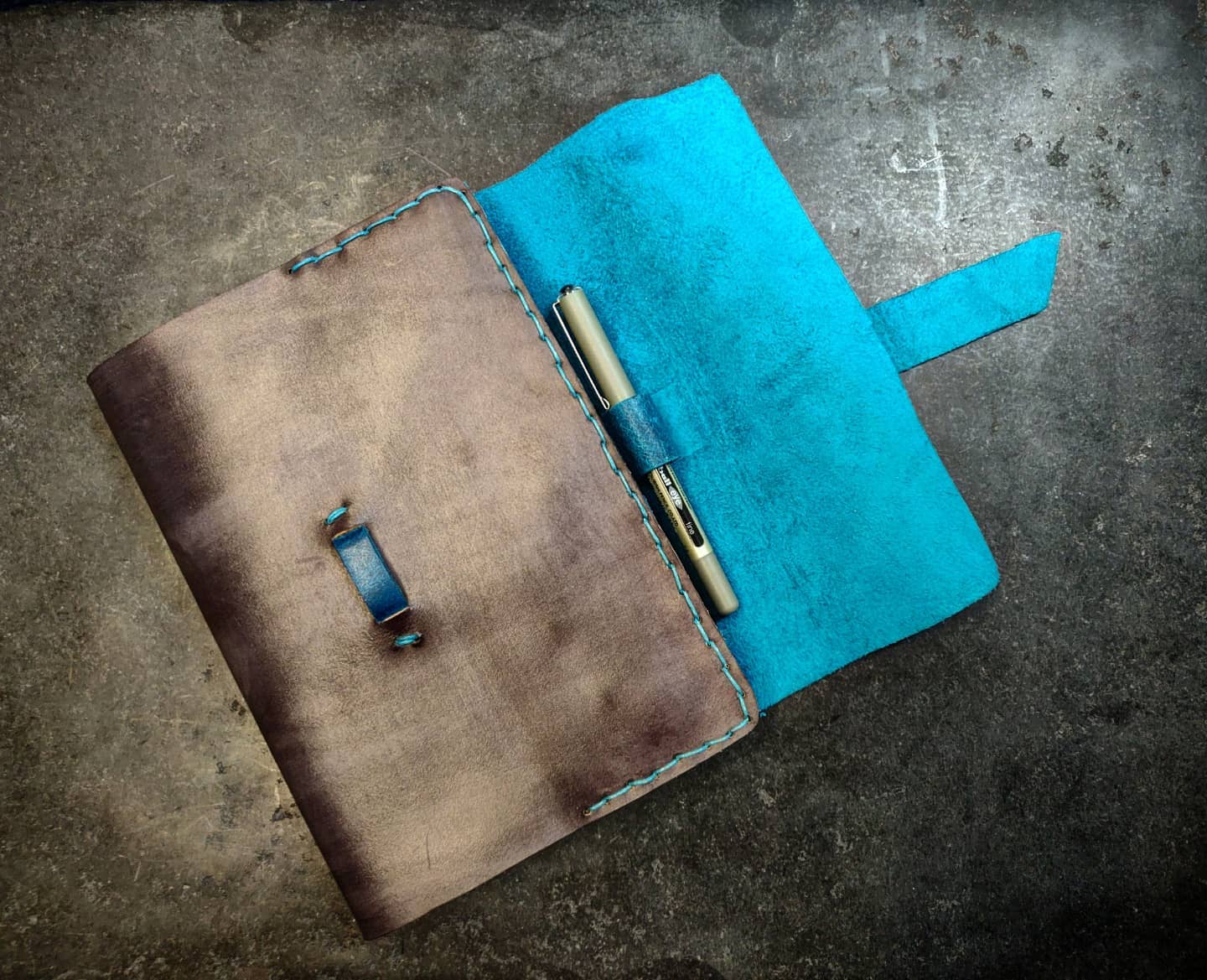 Journal with flap open to reveal pen holder on the right hand side 
