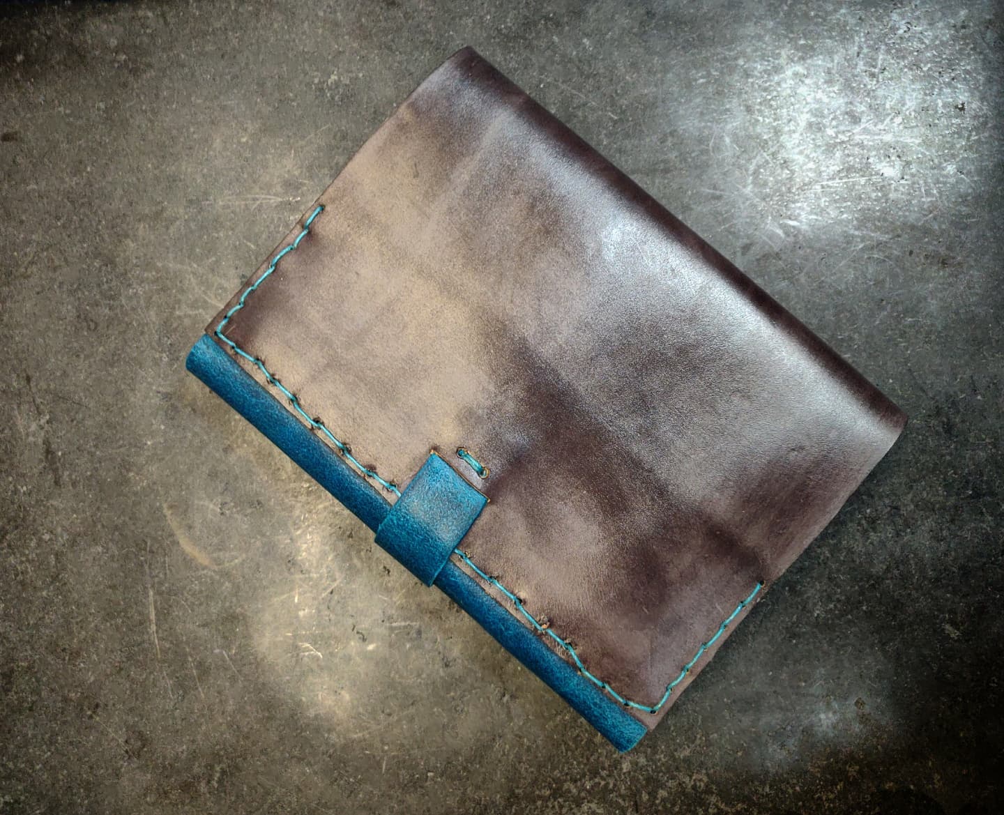 Back cover in grey leather and a view of the blue stitch 