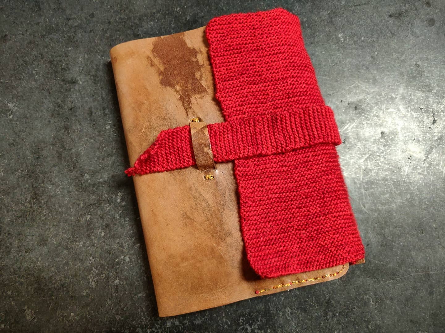 Natural tan leather and red knit journal with a flap and strap