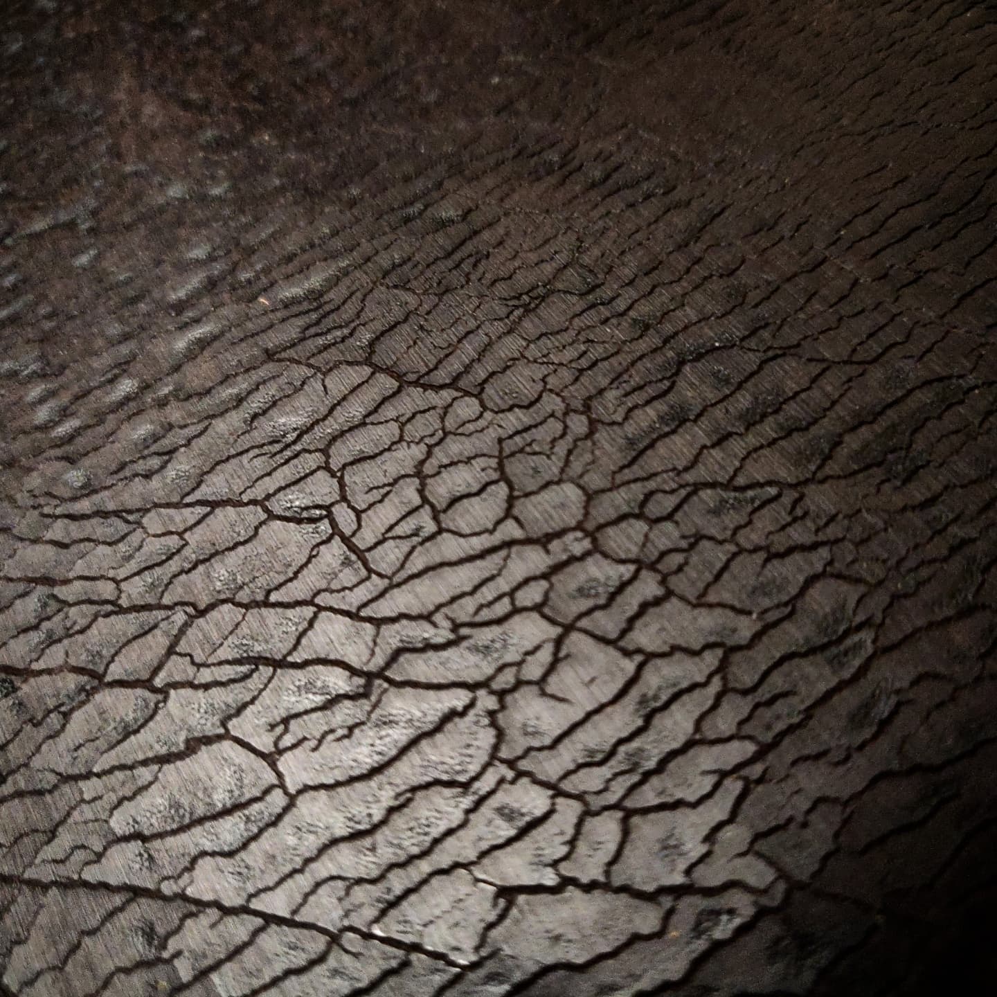 Detailed view of the cracked leather almost with the same feel and look to it as cracked dry soil