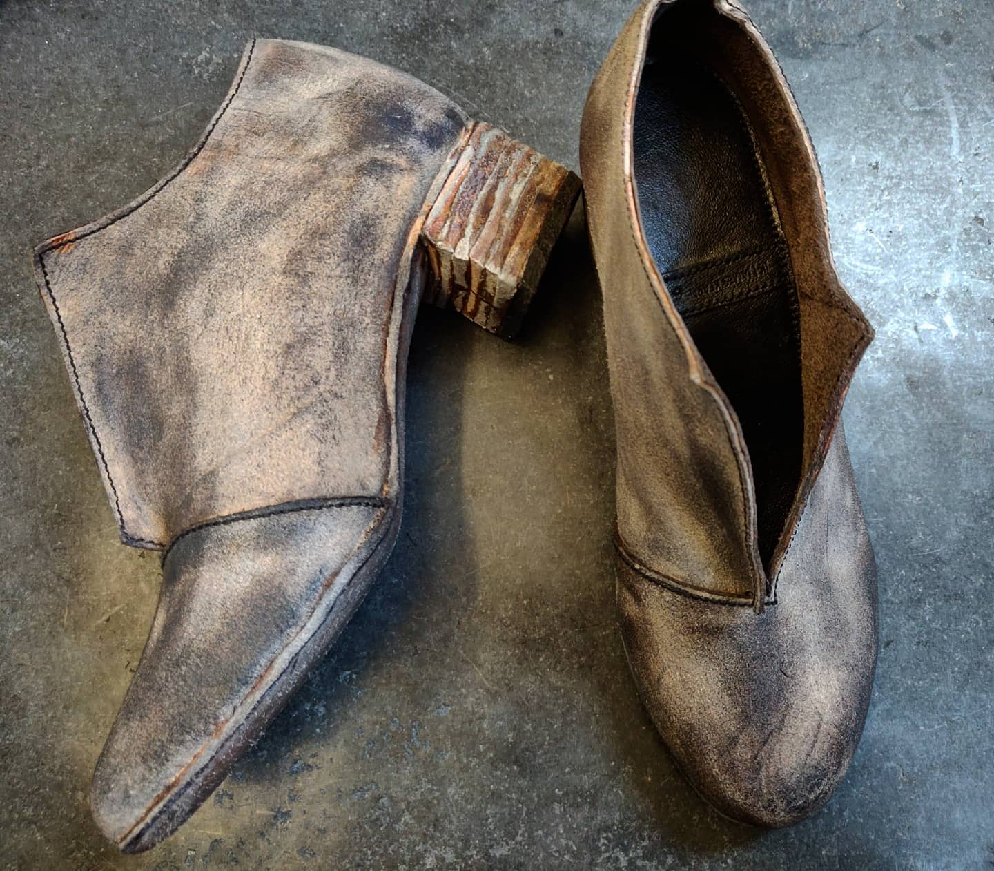 Grey leather boots with a 5cm block heel and leather soling. The boots have an opening at the front just over the vamp area to allow for no use of zips or laces. The colors are various shades of grey on the leather as opposed to an uniform dye.