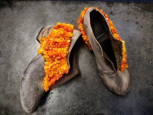 Same design as Spec of Ash boot (grey leather top, 5cm block heel, leather soling, opening on the front) with a asymmetric knit starting on the external side, going over the heel area, under the heel and then emerging on the outside side again. The knit is very chunky and curly in orange hues - from light to deep orange 