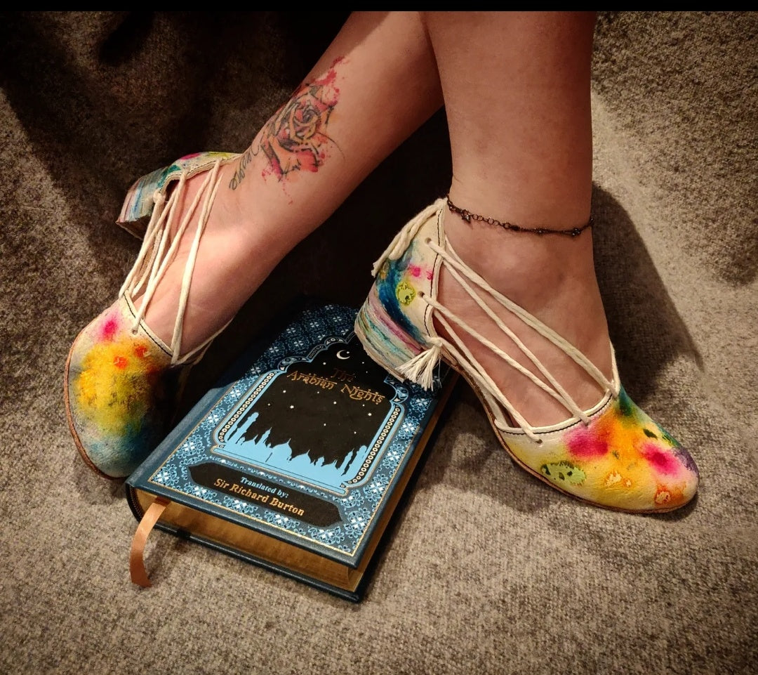 Myself modelling the shoes next to a book in blue leather with the title Arabian nights, which gave the pair the name 