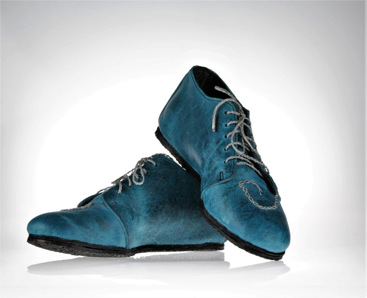Side and top view of the shoes with focus on the shades of blue the leather has. It's not uniform, they are almost blending in darker and lighter and have a beautiful depth to them.