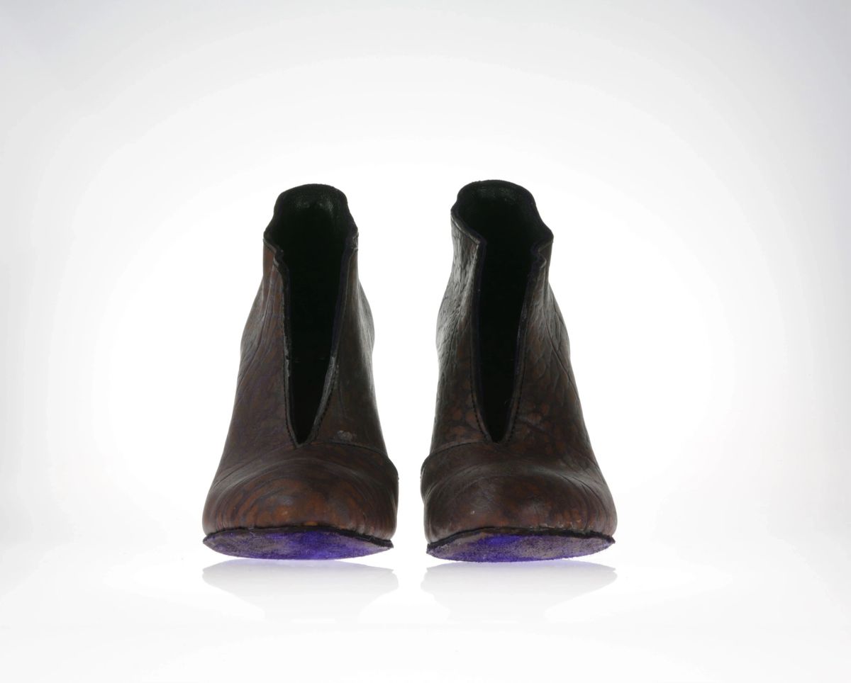 Front view of the shoes with focus on the vibrant purple soling and the opening at the front. 