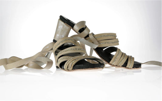 Summer strappy sandals in nude leather. Each of the straps has a hand sawn silver an gold stich in a cain which adds elements of shine and interest. The heel is 5cm. To wrap these sandals there are two long strips of leather which can go up on the ankle or around the leg